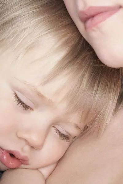 Mother cuddling sleeping son — Stock Photo, Image