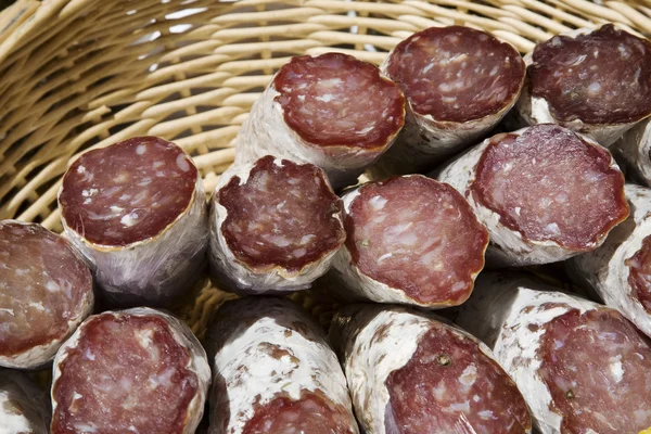 Salami, kiełbasy w wiklinowym koszu — Zdjęcie stockowe