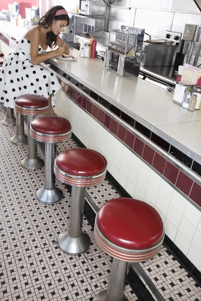 Mujer sentada en la barra de comedor — Foto de Stock