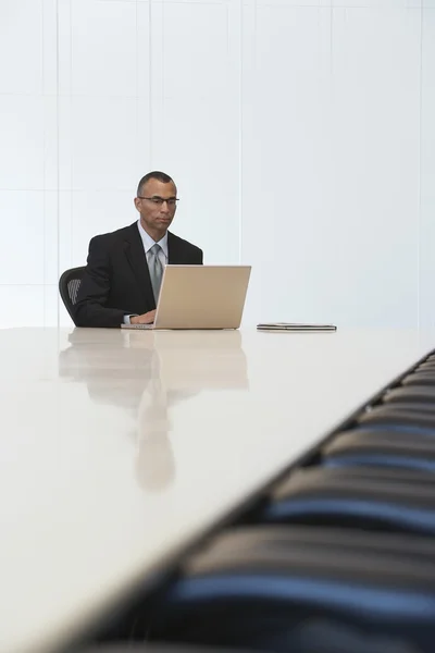 Businessman using laptop in board room — Stock Photo, Image