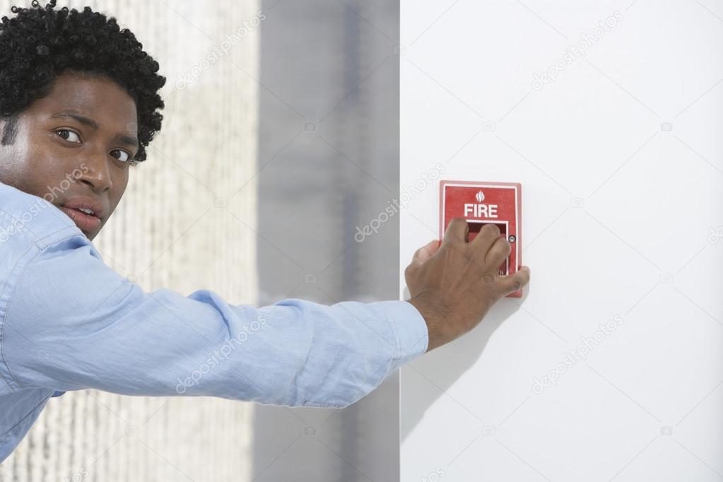 Businessman starting fire alarm