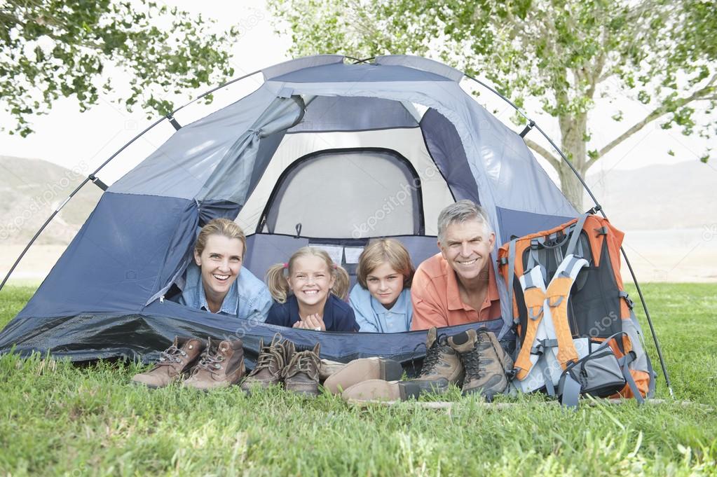 Family smiling from a tent