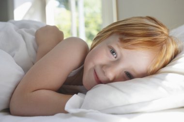 neşeli kız yatakta yatan