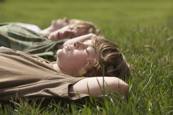 Three teenage brothers  on grass — Stock Photo, Image