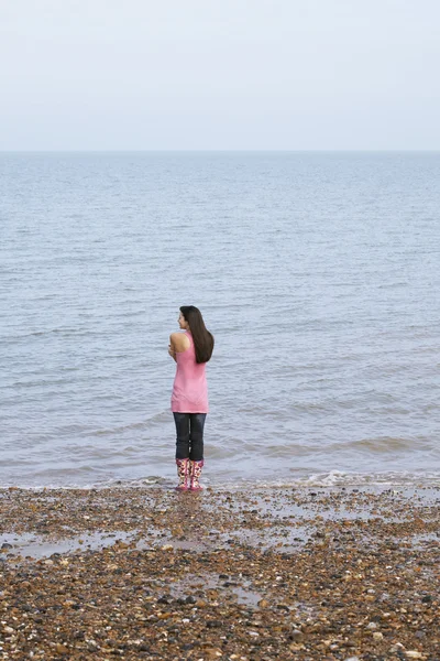 Kvinna stående på stranden — Stockfoto