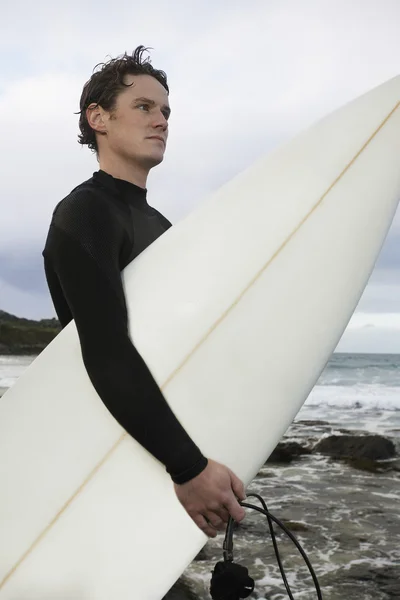 Homem com prancha de surf na praia — Fotografia de Stock