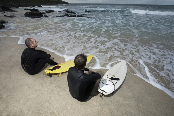 Dois surfistas sentados na praia — Fotografia de Stock