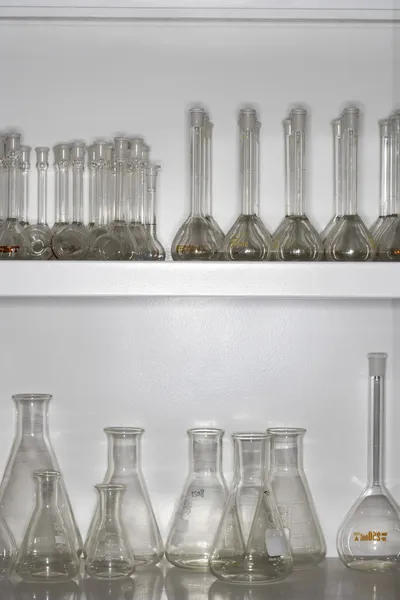 Laboratory flasks on shelves — Stock Photo, Image