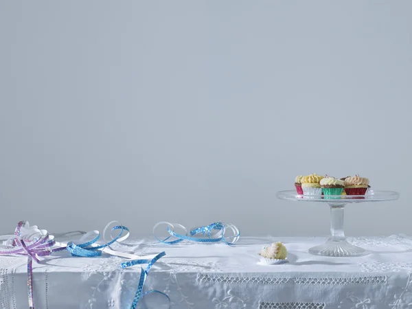 Streamers and cup cakes on table — Stock Photo, Image