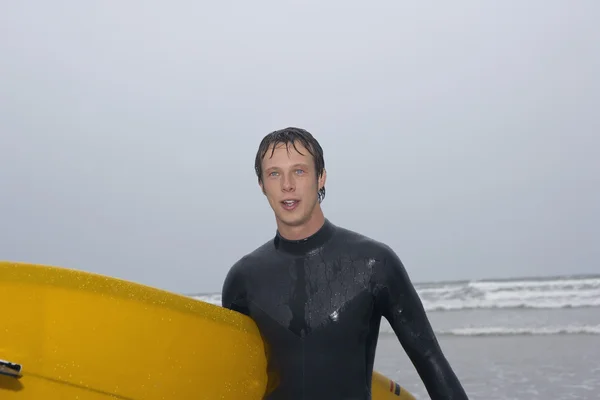 Surfeur portant une planche de surf — Photo