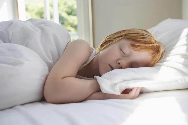 Meisje slapen in bed — Stockfoto