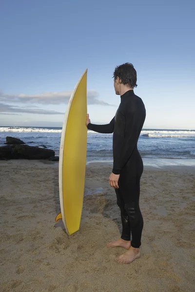 Человек держит доску для серфинга — стоковое фото