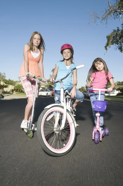 Children with scooters and bicycle — Stock Photo, Image