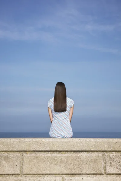 Taş kenarında oturan kadın — Stok fotoğraf