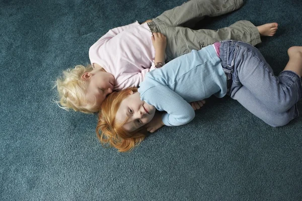 Sisters lying on carpet — Stock Photo, Image