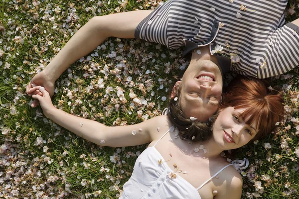 Casal deitado na grama — Fotografia de Stock