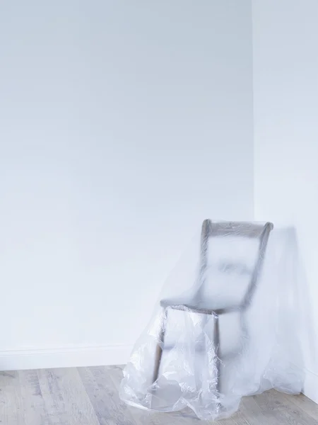 Chair covered by plastic — Stock Photo, Image