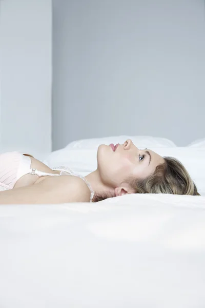 Vrouw in ondergoed liggend op bed — Stockfoto