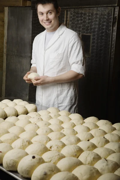 Boulanger avec des boules de pâte à pain prêt à cuire — Photo