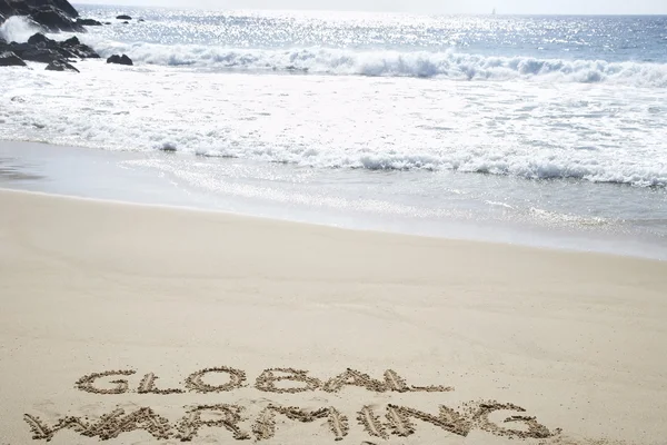 Globale opwarming van de aarde tekst geschreven in strand — Stockfoto