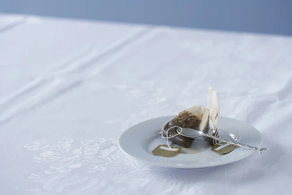 Theezakje gebruikt op schotel op tafel — Stockfoto