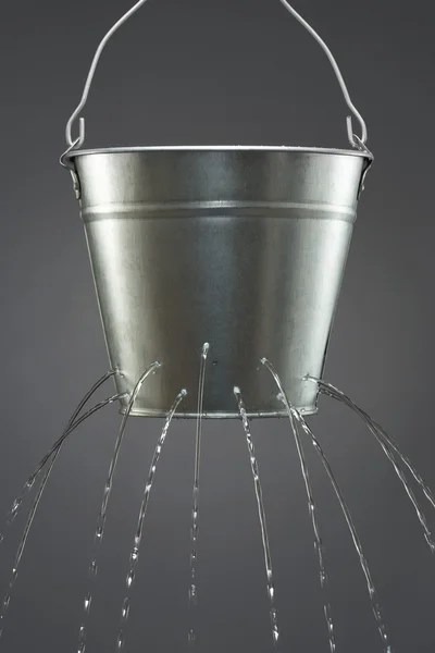 Water leaking from bucket — Stock Photo, Image