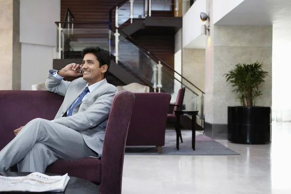 Hombre de negocios sentado en el sofá — Foto de Stock