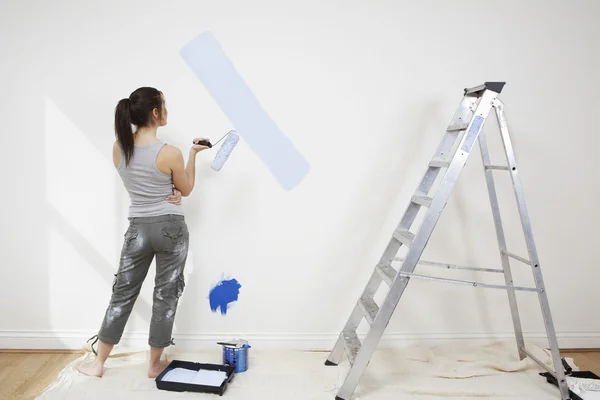 Vrouw schildert muur — Stockfoto