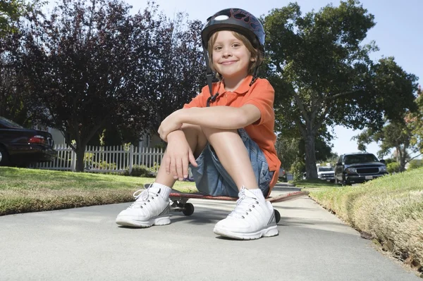 Pojke sitter på skateboard — Stockfoto