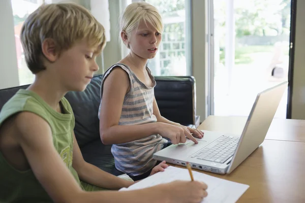 Frères et sœurs faisant leurs devoirs — Photo