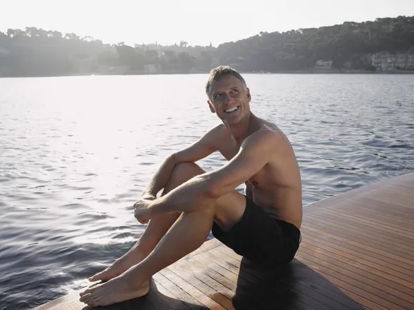 Man Sitting by Water — Stock Photo, Image