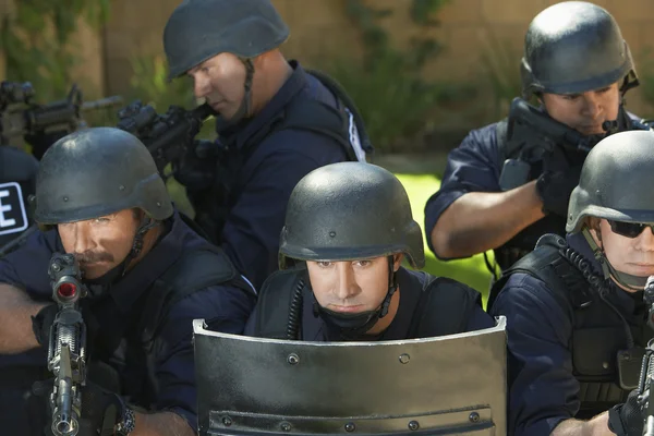 Officers behind shield — Stock Photo, Image