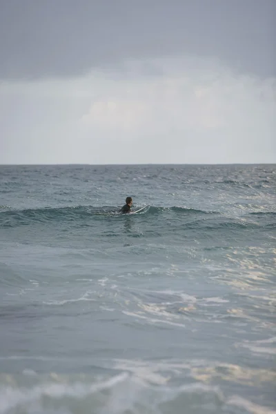 Surfeur assis sur une planche de surf en mer — Photo