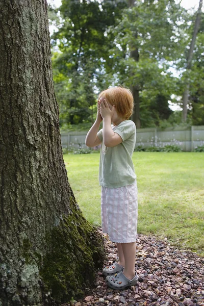 Flickan står framför trädet — Stockfoto