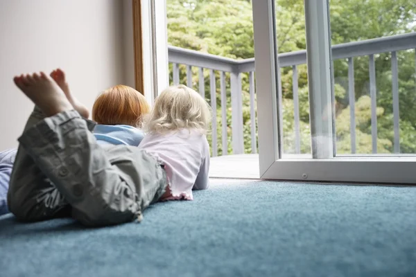 Schwestern liegen auf Teppich — Stockfoto