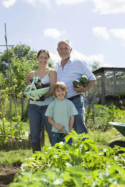 Familj med pojke håller grönsaker — Stockfoto