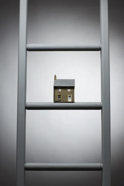 Kleine model van huis op ladder — Stockfoto