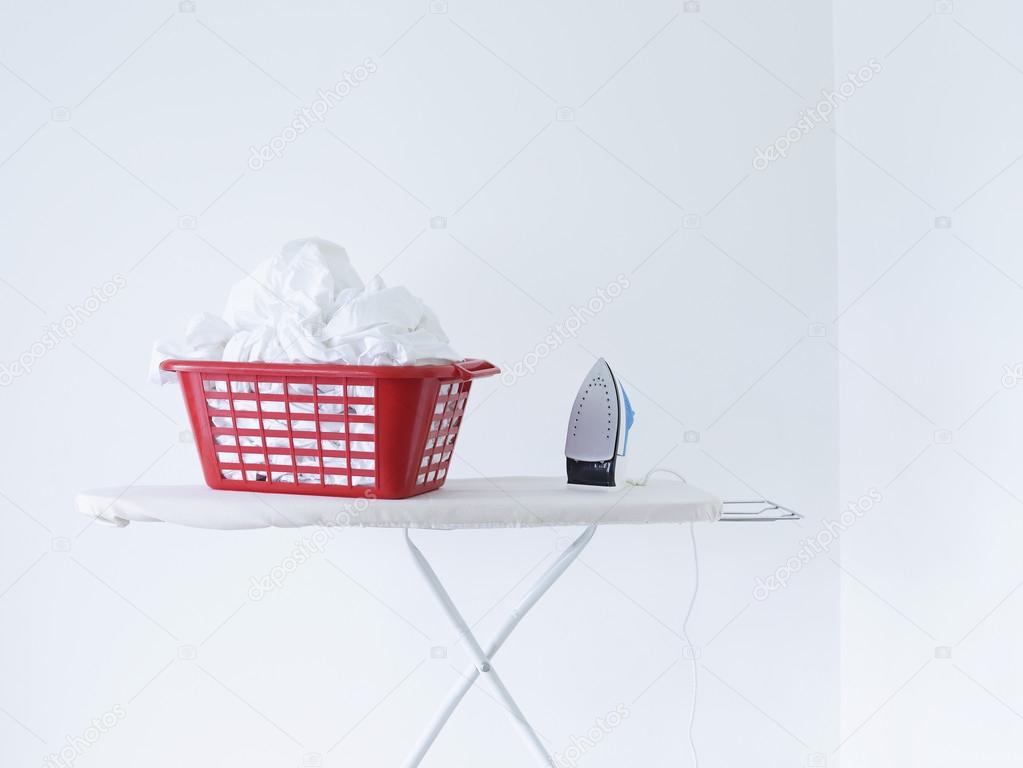 Iron and laundry basket on ironing board