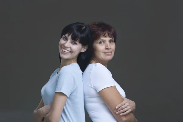 Woman and mother standing back to back — Stock Photo, Image