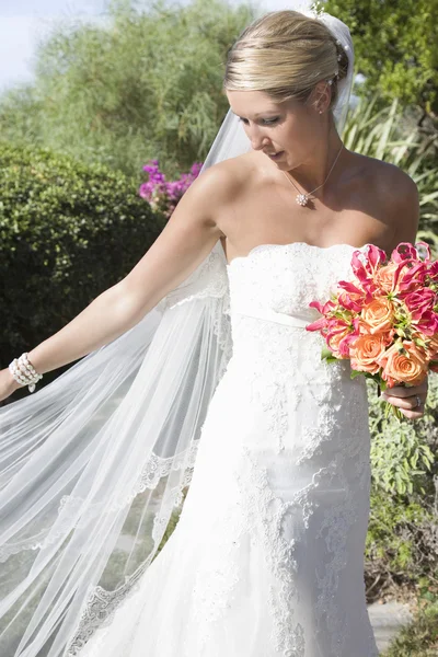 Braut hält Blumenstrauß — Stockfoto