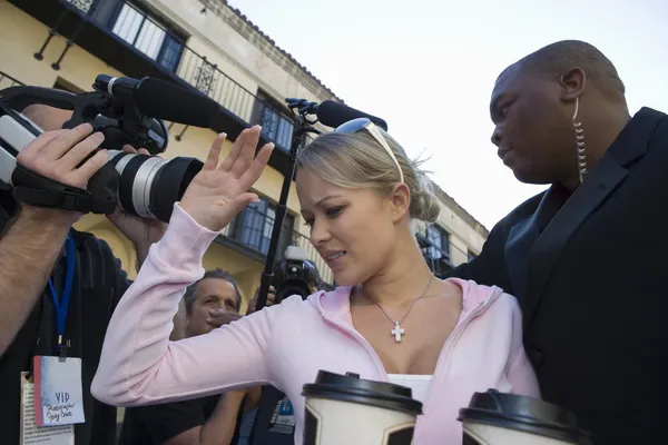 Celebridad femenina con guardaespaldas y paparazzi — Foto de Stock