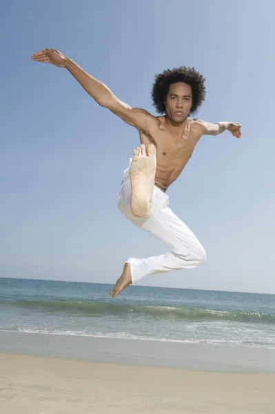 Mannen som trener på stranden – stockfoto