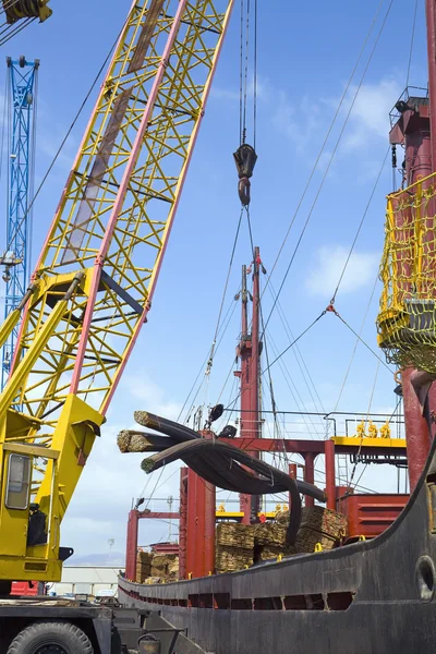 Crane unloading steel rods — Stock Photo, Image