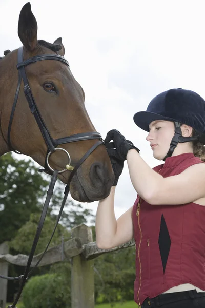 Chica apretando la brida del caballo —  Fotos de Stock