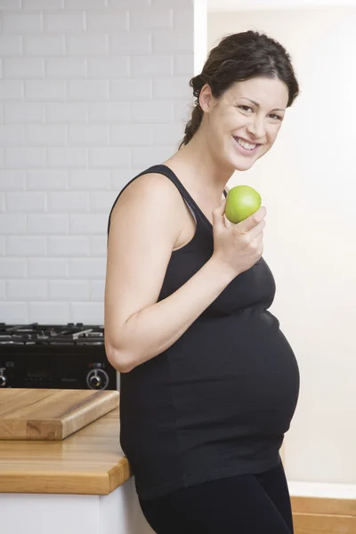 Mujer embarazada comiendo manzana — Foto de Stock