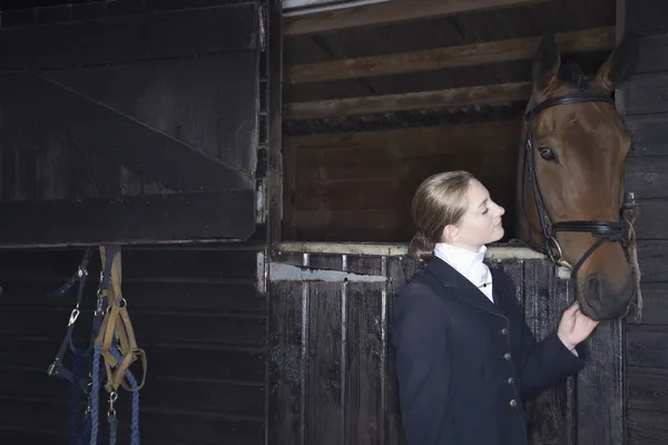 Horseback rider with horse in stable — Stock Photo, Image