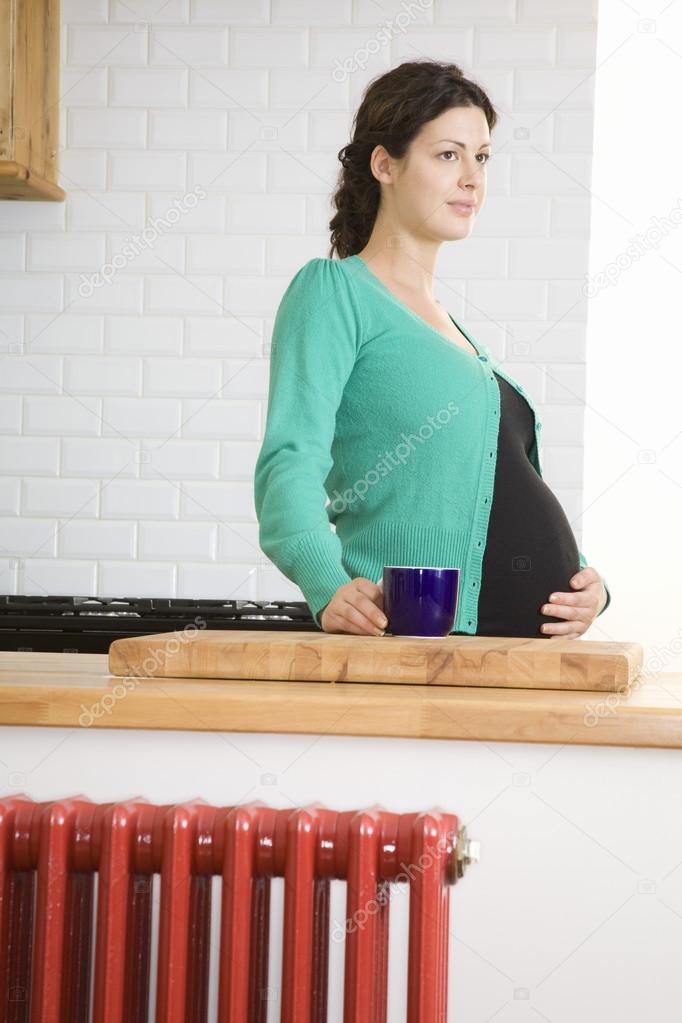 Woman drinking tea in kitchen