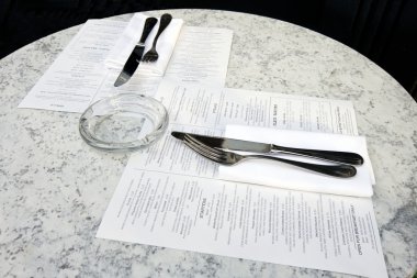 Cafe table with cutlery and menus clipart