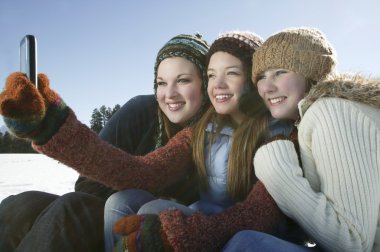 Üç kız kendi kendine portre fotoğraf makinesi telefon ile al