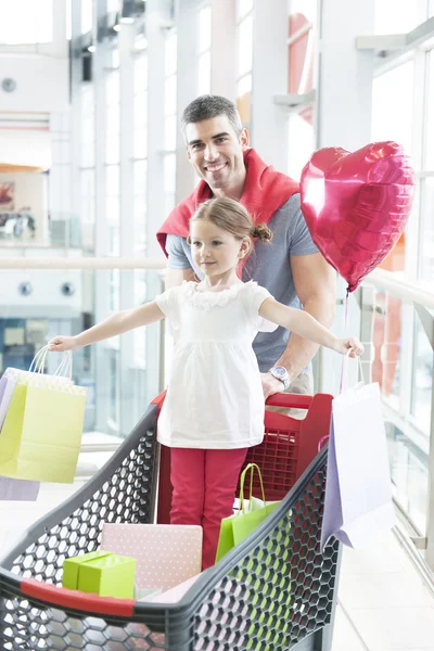 ショッピングトロリーで押すことの娘を父します。 — ストック写真